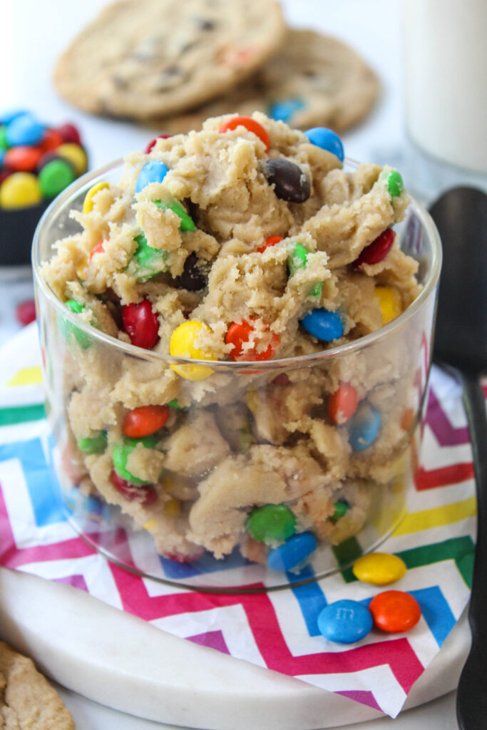 Creamy edible M&M cookie dough with colorful chocolate candies mixed throughout


