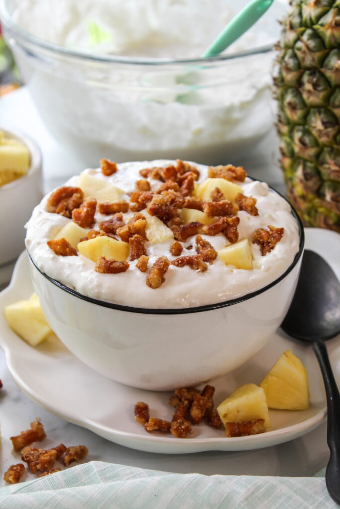 Close-up of pineapple pretzel fluff dessert, showing a creamy texture with bits of crushed pretzels and bright yellow pineapple