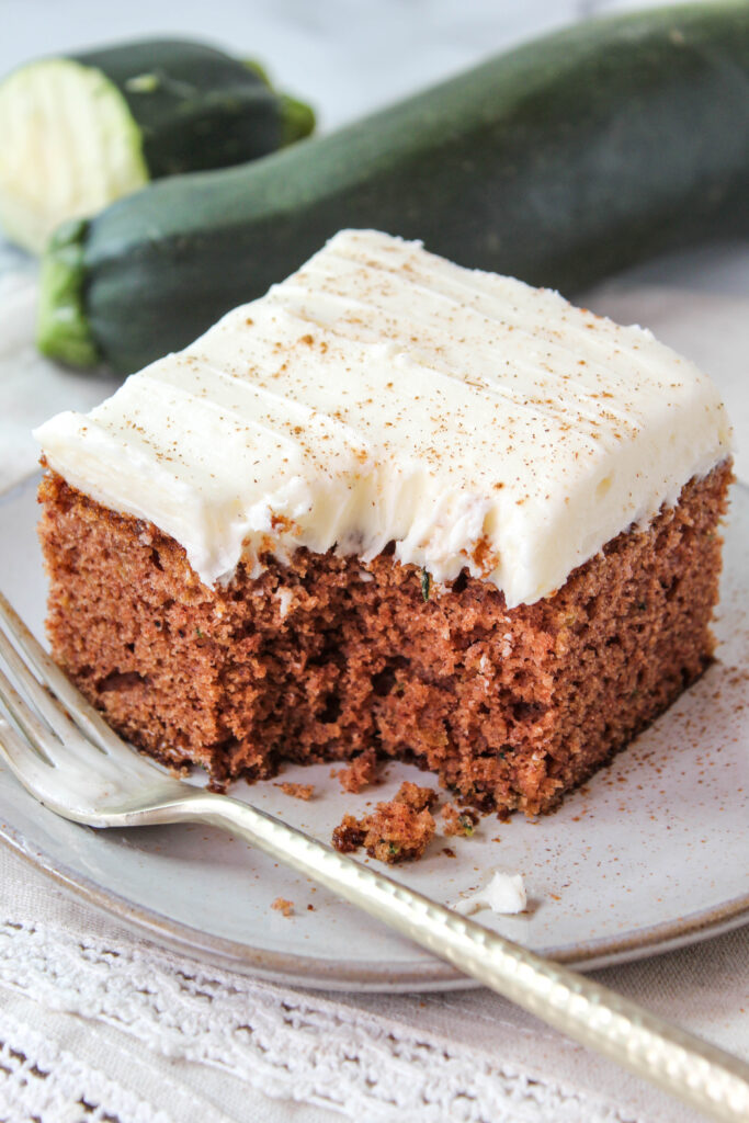 A soft, moist cake made with shredded zucchini hidden in cinnamon and spice and topped with cream cheese frosting!