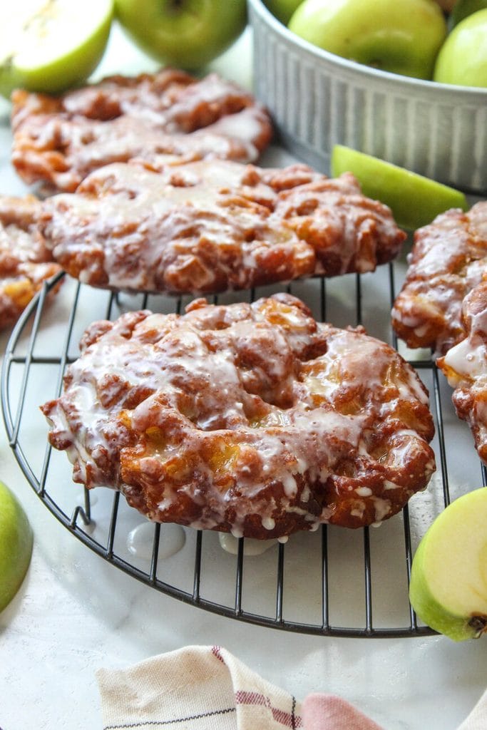 Golden apple fritters with crispy edges and a sweet vanilla glaze