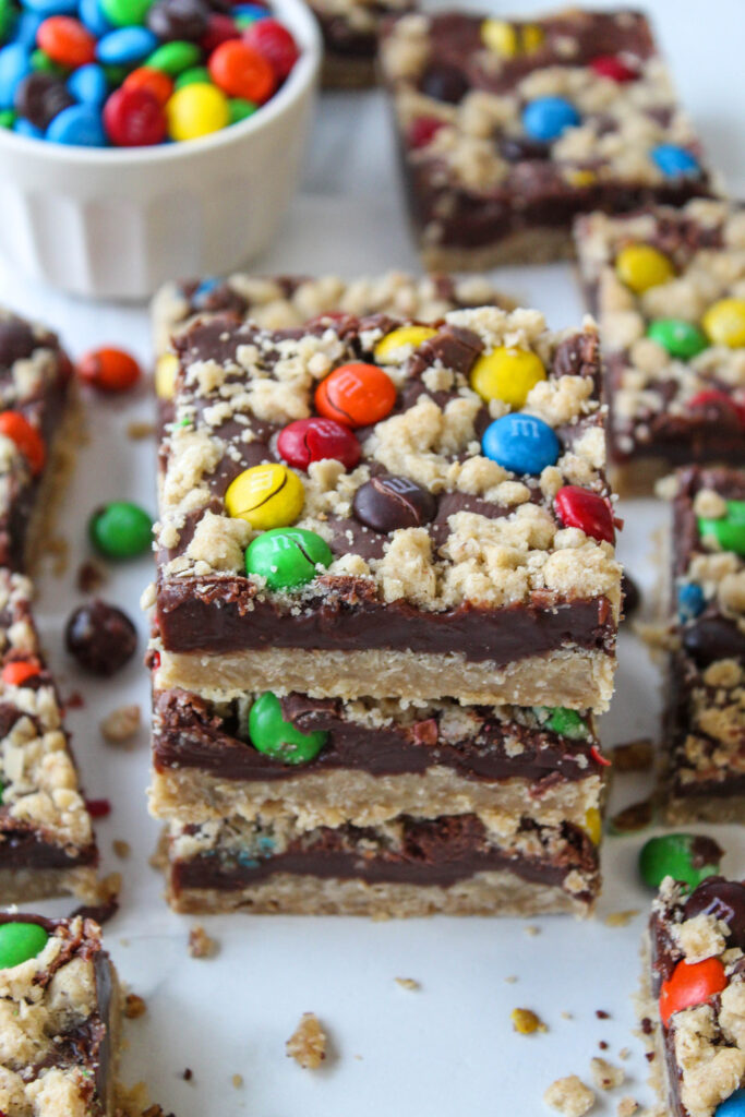 Close‑up of gooey M&M chocolate bars showing layers of oats and melted chocolate