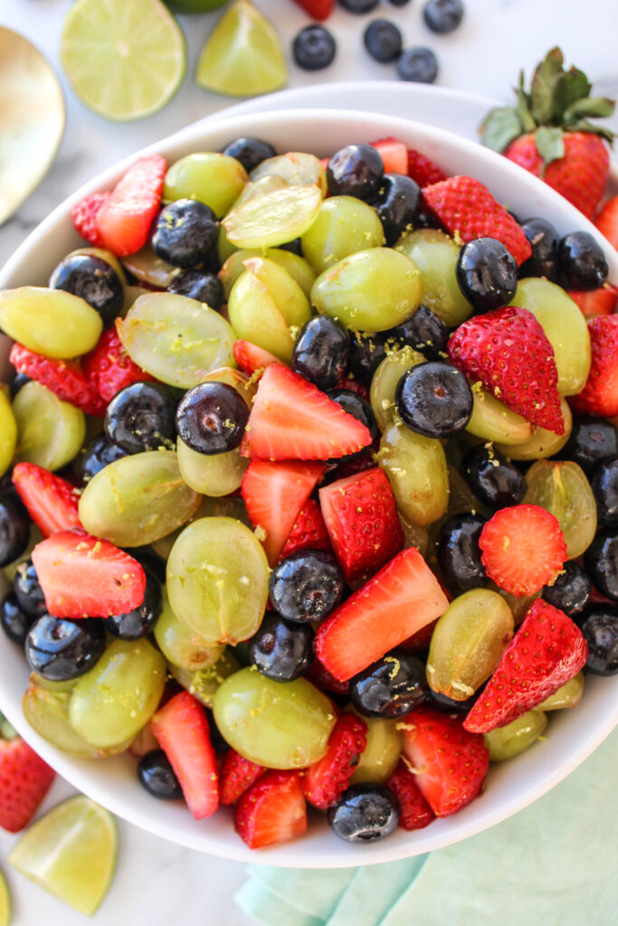 Overhead view of honey lime fruit salad made with fresh berries and grapes