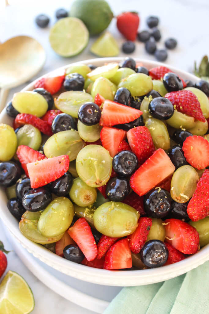 Honey lime fruit salad served in a bowl with fresh fruit