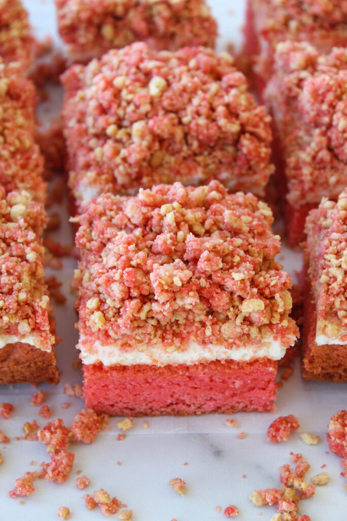 Strawberry crunch cheesecake brownies with a strawberry brownie base, creamy cheesecake layer, and crunchy strawberry topping