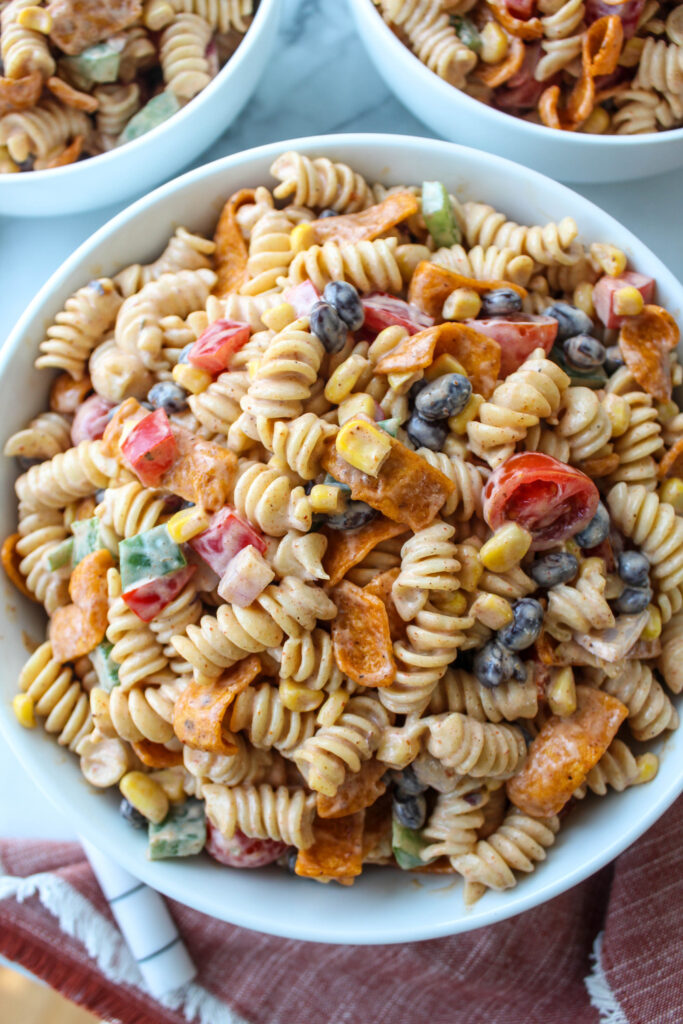 Overhead view of ranch taco pasta salad with rotini pasta, colorful vegetables, and frito chips