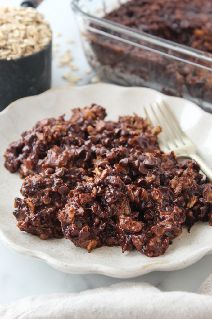 A rich, chocolate brownie baked oatmeal with a slightly cracked top and pockets of melted chocolate throughout