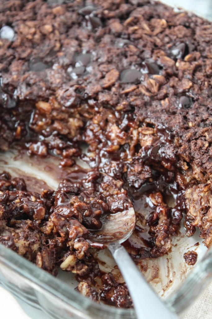 A dense, cocoa-infused baked oatmeal resembling a brownie, with a moist center and lightly crisp edges