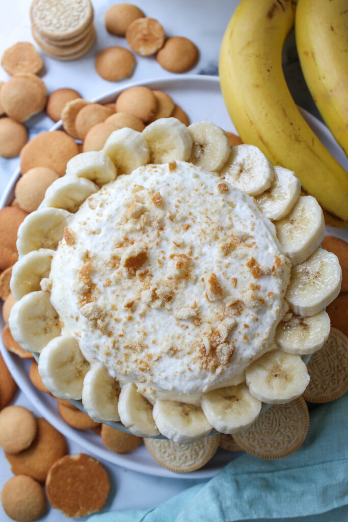 Banana cream pie dip in a bowl with whipped topping and bananas