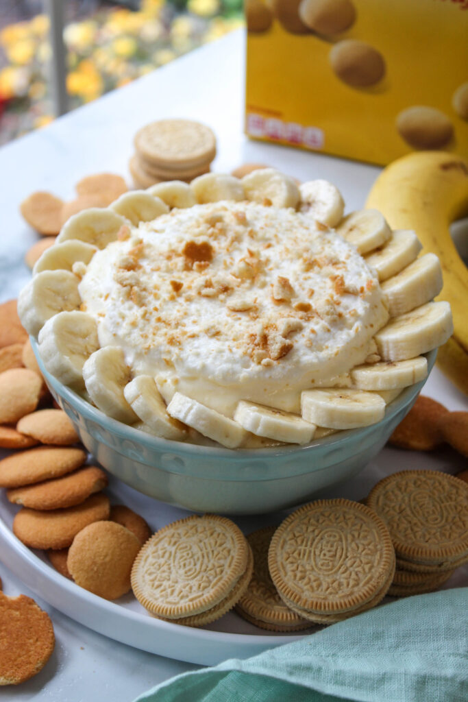 Fluffy banana cream pie dip made with whipped topping, garnished with banana slices and crushed Nilla wafers