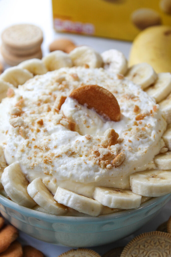 Banana cream dessert dip served in a bowl with sliced bananas and vanilla wafer topping