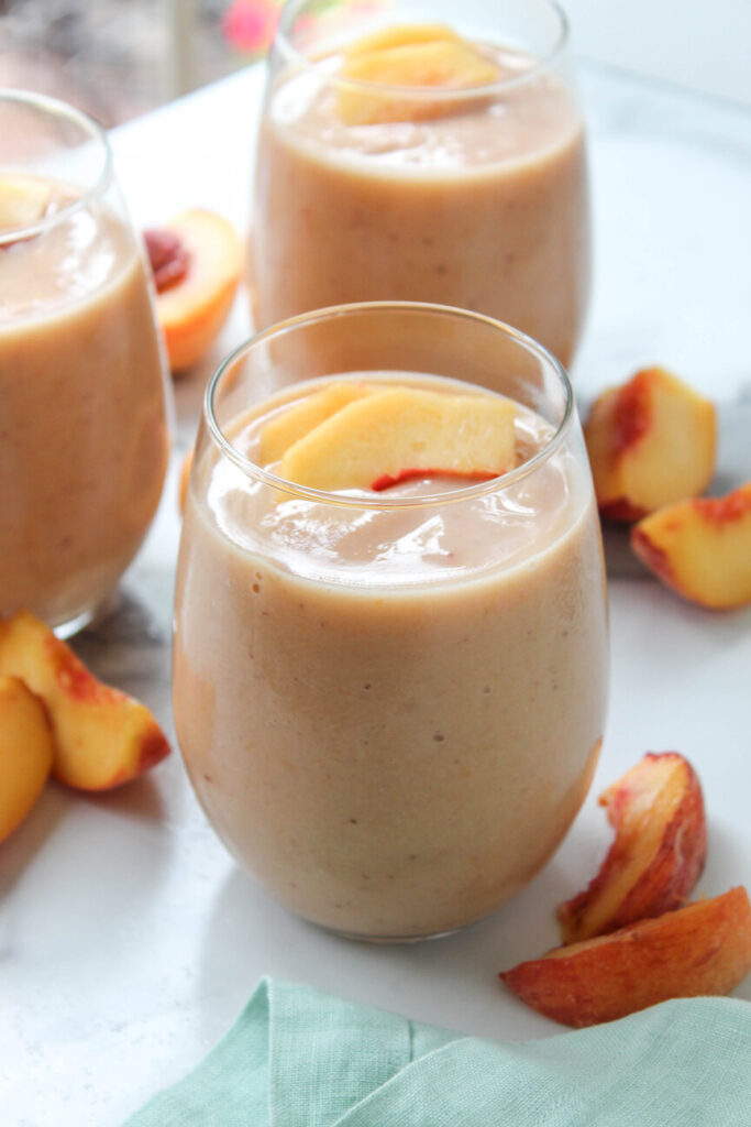 Glass of creamy peach smoothie made with frozen peaches, ready in 5 minutes