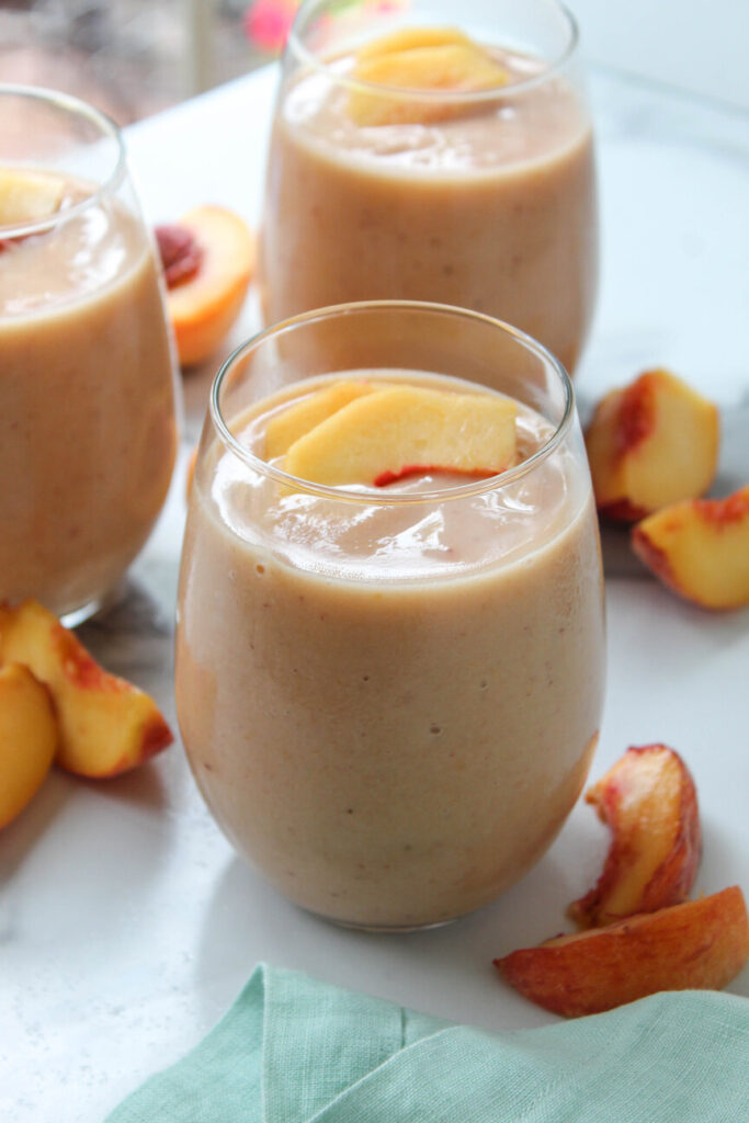 Refreshing peach smoothie in a glass with straws, quick 5-minute recipe