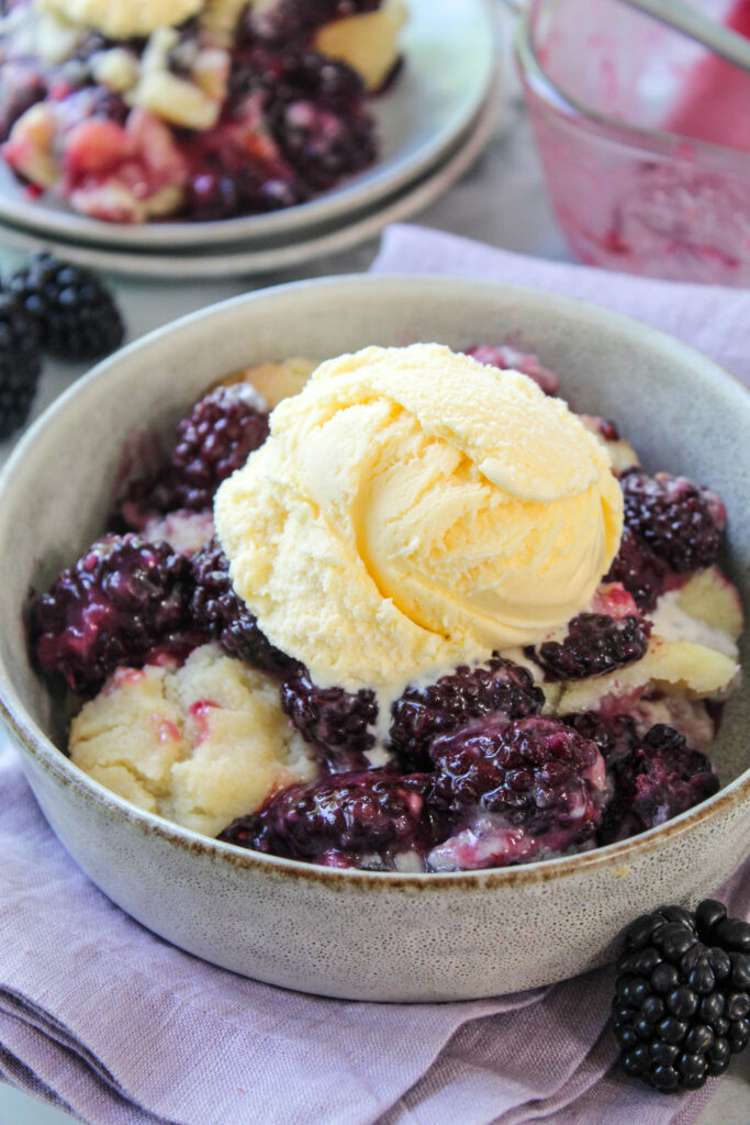Fresh blackberry cobbler served warm with a scoop of vanilla ice cream