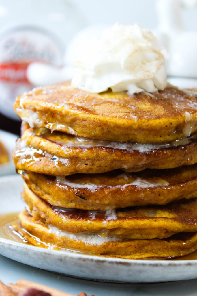 Golden pumpkin spice pancakes served on a white breakfast plate