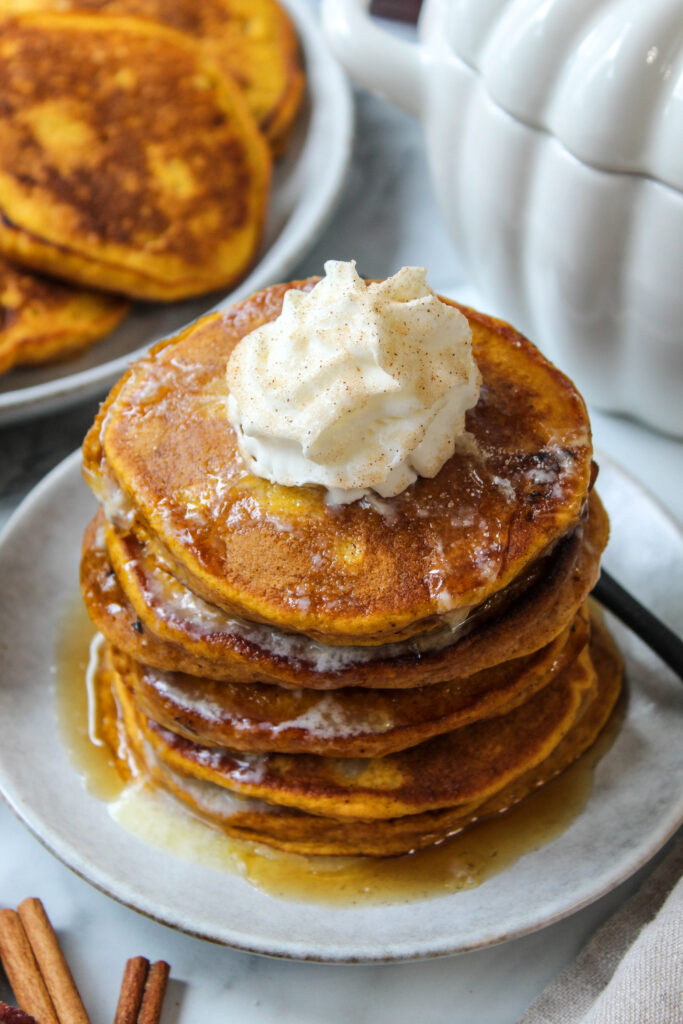 Thick and fluffy pumpkin pancakes drizzled with warm maple syrup