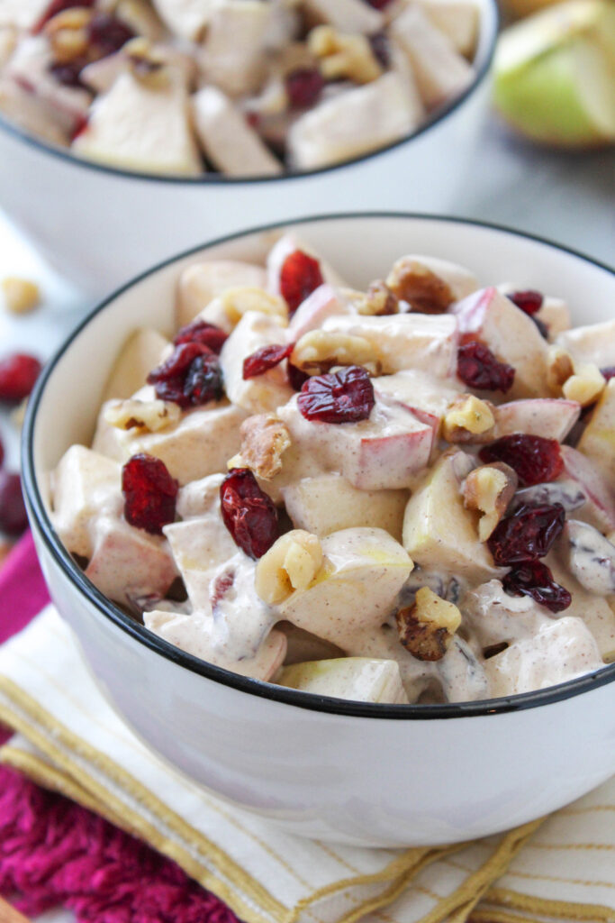 Apple cinnamon fruit salad topped with crunchy walnuts and creamy dressing