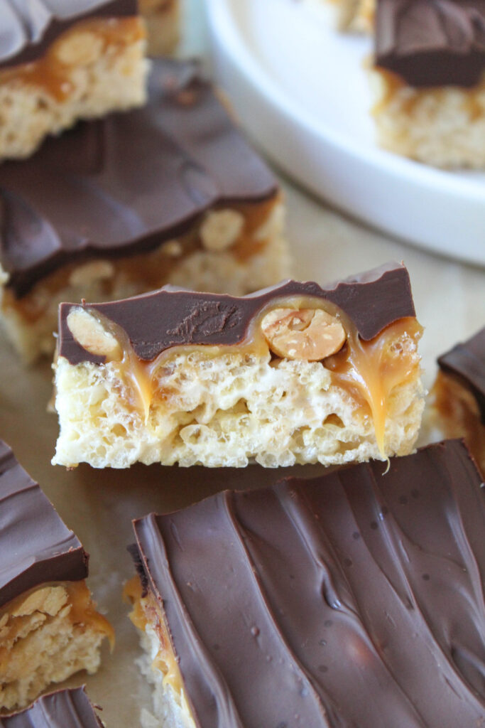 Close-up of gooey Snickers Rice Krispie treat with chocolate and peanuts