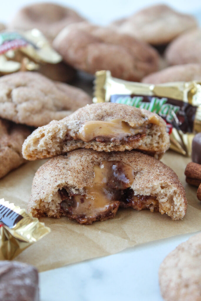 Soft snickerdoodle cookies filled with melted Milky Way candy bars, showing a rich caramel-chocolate filling