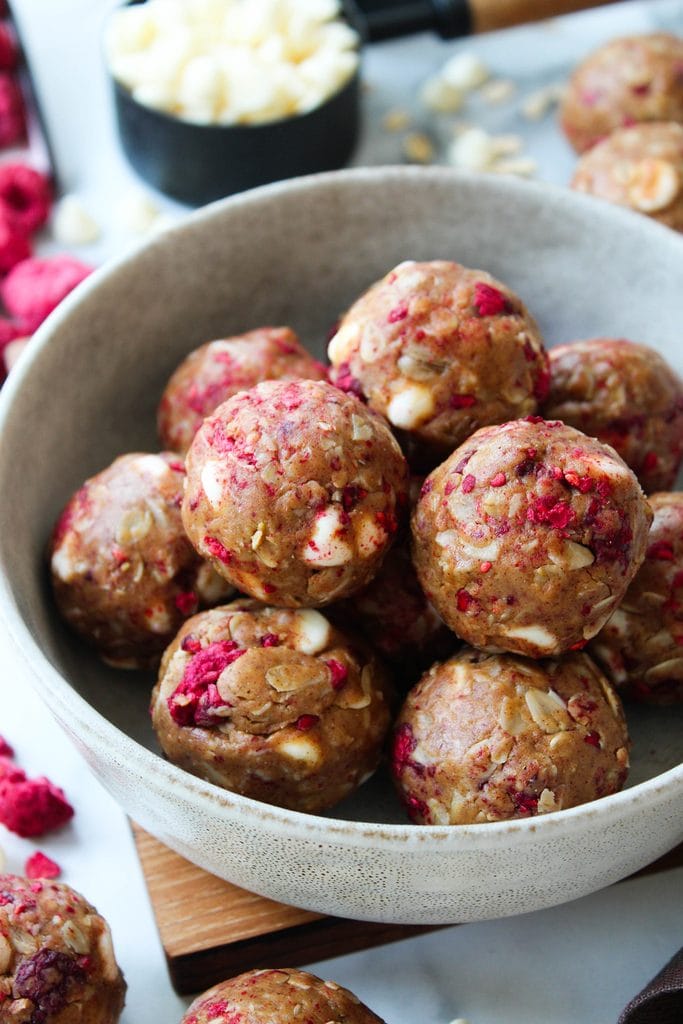No‑bake raspberry protein bites with white chocolate coating and pink flecks