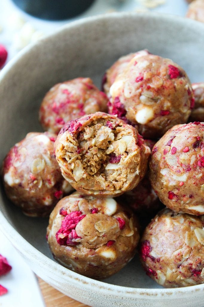 White chocolate raspberry protein balls showing the center with berry chunks