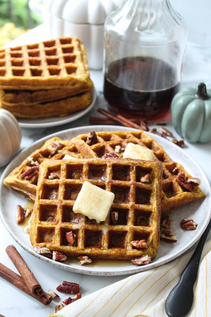 Warm pumpkin waffles served for breakfast with syrup
