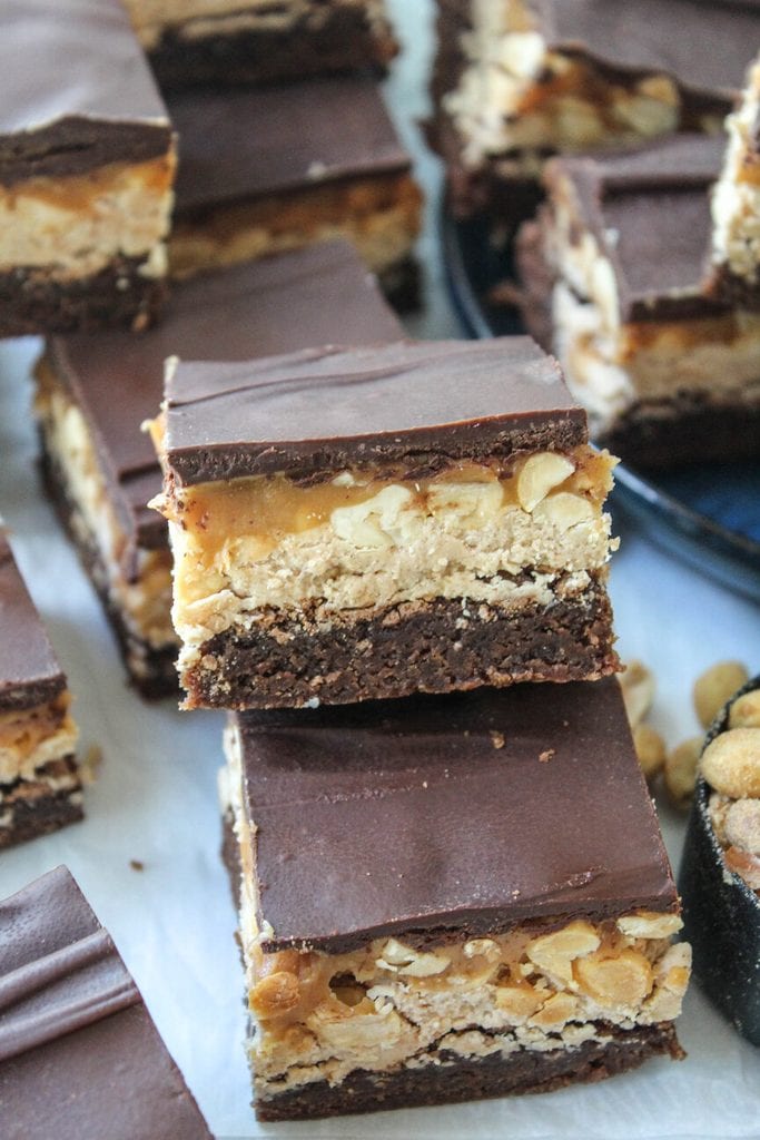 Close‑up of fudgy Snickers brownies showing thick nougat and caramel layers