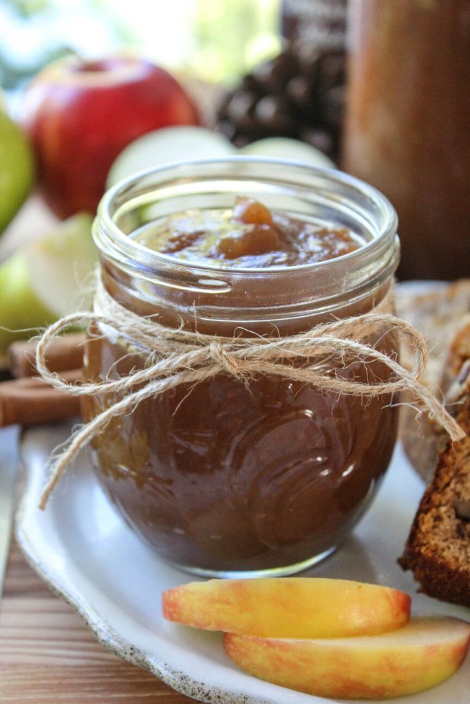 Jar of homemade crock pot apple butter with a rich cinnamon color