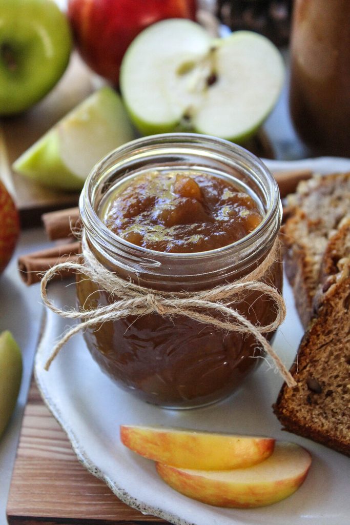 Slow‑cooked apple butter cooling in jars on a fall‑themed table