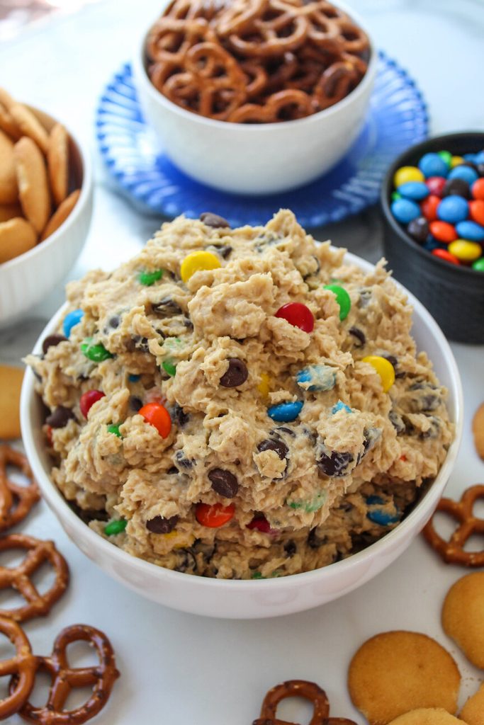 Creamy peanut butter monster cookie dough dip in a white serving bowl