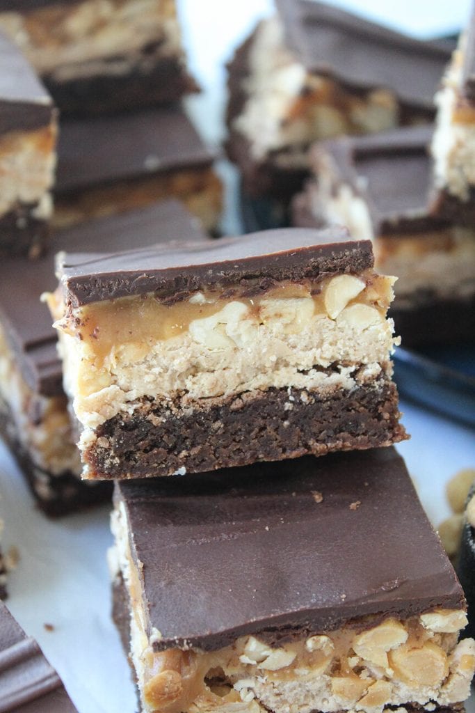 Cut Snickers brownies showing distinct brownie, nougat, caramel, and chocolate layers