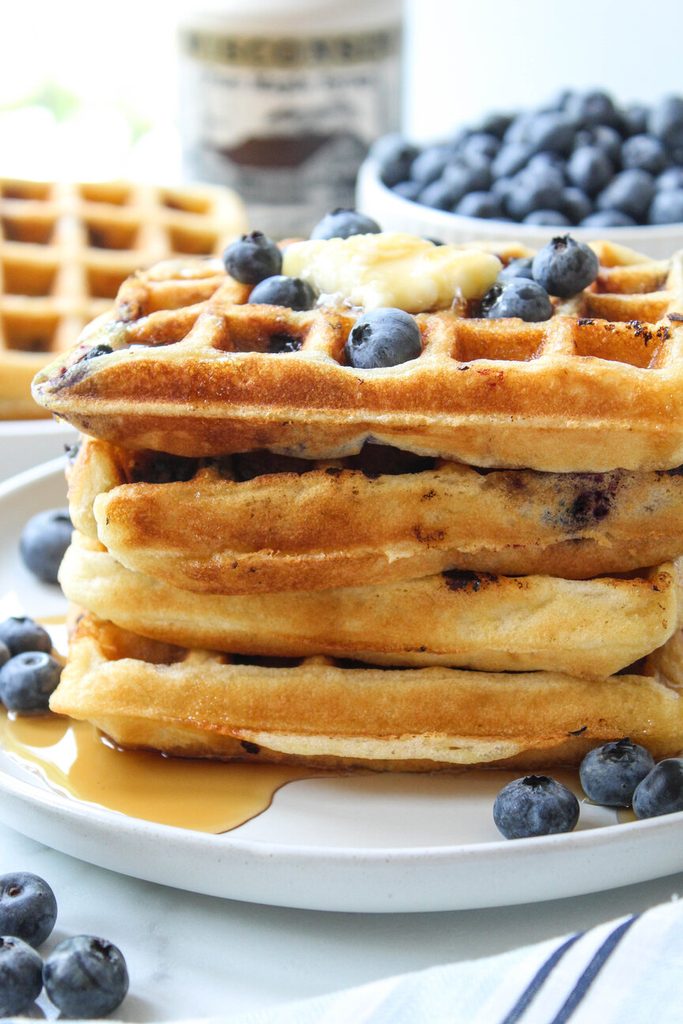 Close‑up of fluffy blueberry waffles showing crisp texture and burst blueberries
