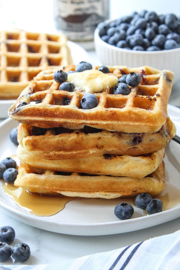Blueberry waffles with deep pockets filled with melted butter and syrup