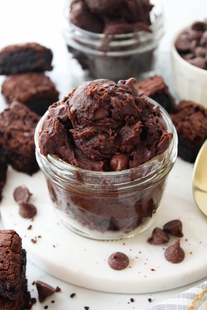Fudgy edible brownie batter in a glass jar showing glossy texture