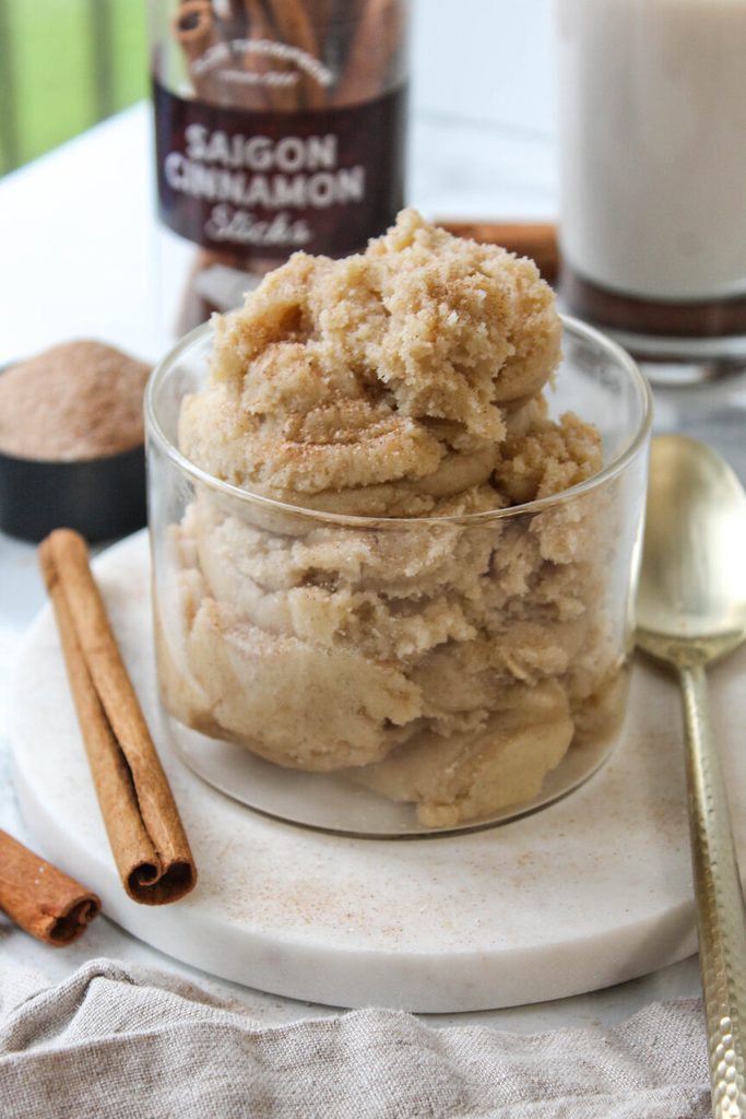 Edible snickerdoodle cookie dough in a glass bowl with cinnamon‑sugar topping