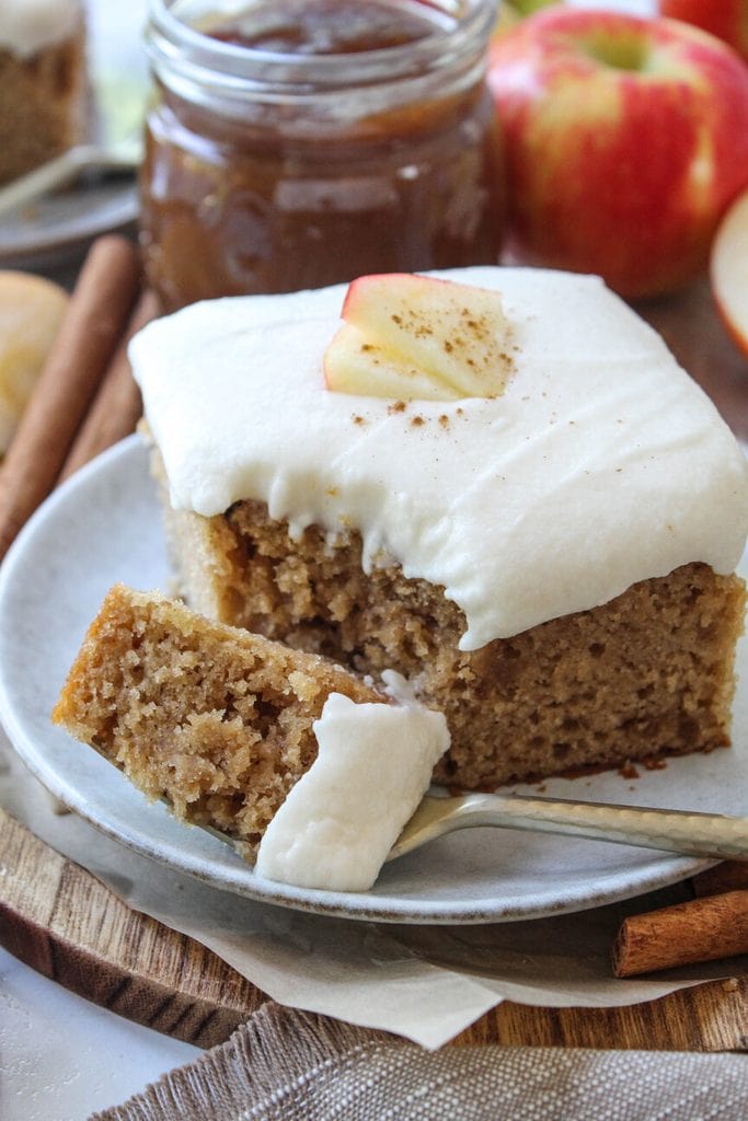 Apple butter cake on a wooden board with apple slices around